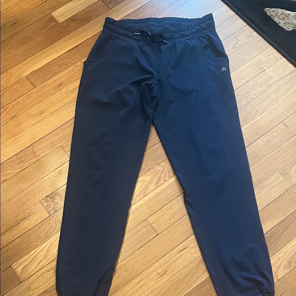 Navy blue joggers, with side pockets, and zippered back pockets.